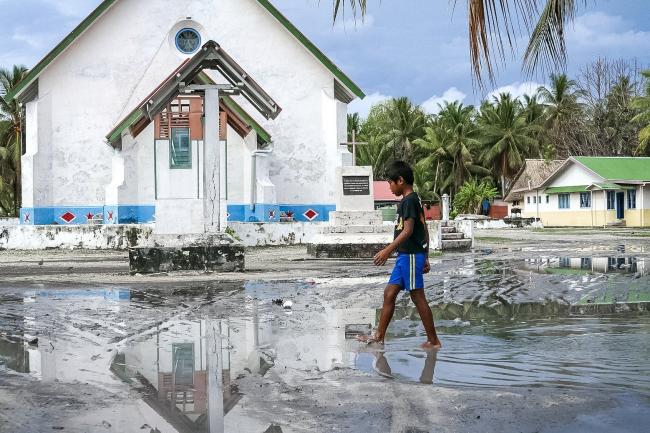 A child in Tuvalu walks through damage from Cyclone Pam. Photo by Silke von Brockhausen / UNDP (CC BY-NC-ND 2.0)