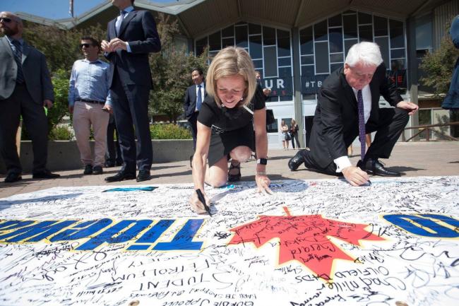 Alberta Premier Rachel Notley and Kinder Morgan Canada president Ian Anderson sign a message of support for pipeline expansion at an event in Calgary on May 30, 2018. Twitter photo posted by Rachel Notley