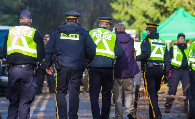 Photo: Canadian police arresting protesters against Kinder Morgan’s Oil Pipeline, 2014. Mark Klotz / Flickr / CC BY 2.0.