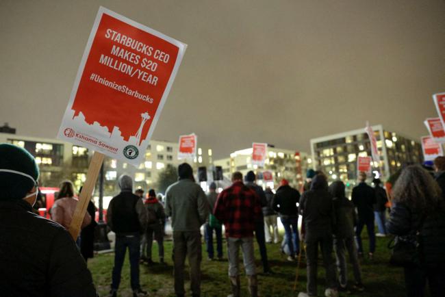 Supporters hold pro-union signs in support of workers of two Seattle Starbucks locations that announced plans to unionize, during an evening rally at Cal Anderson Park in Seattle, Washington, January 25, 2022. JASON REDMOND / AFP VIA GETTY IMAGES