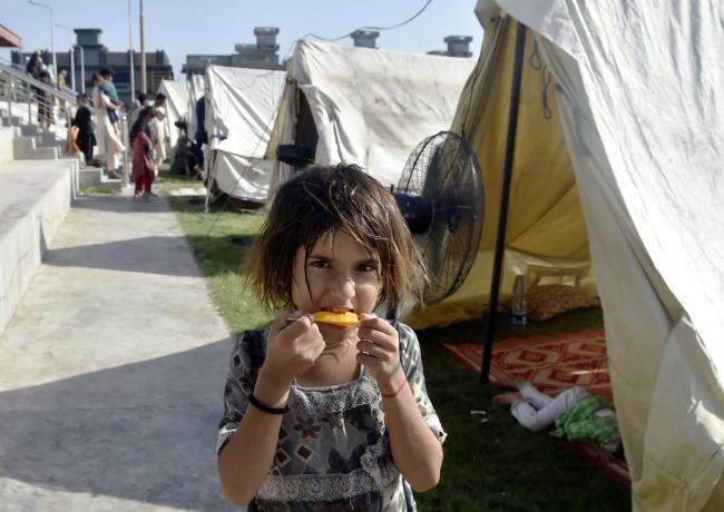 A flood-affected girl eats at a relief shelter in northwest Pakistan's Charsadda on August 31, 2022. An estimated one person every two seconds is being displaced due to a climate catastrophe, according to organizer and writer Harsha Walia. SAEED AHMAD / XINHUA VIA GETTY IMAGES