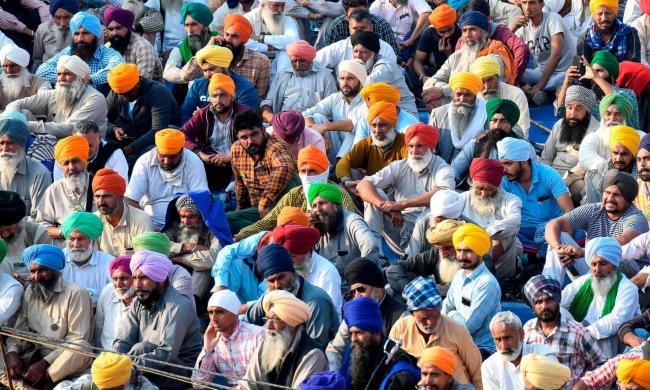 Protesting farmers listen to a speaker at the Delhi-Haryana state border in Singhu . Photograph: Prakash Singh/AFP/Getty Images