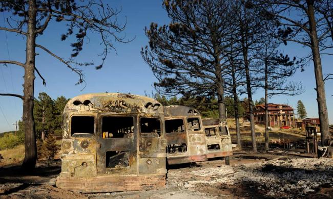 Burned buses at the Colorado Mountain Ranch in the historic town of Gold Hill in the Fourmile Canyon fire area in Boulder, Colorado, attest to the effects of a devastating wildfire, Photograph: Craig F Walker/Denver Post/Getty Images