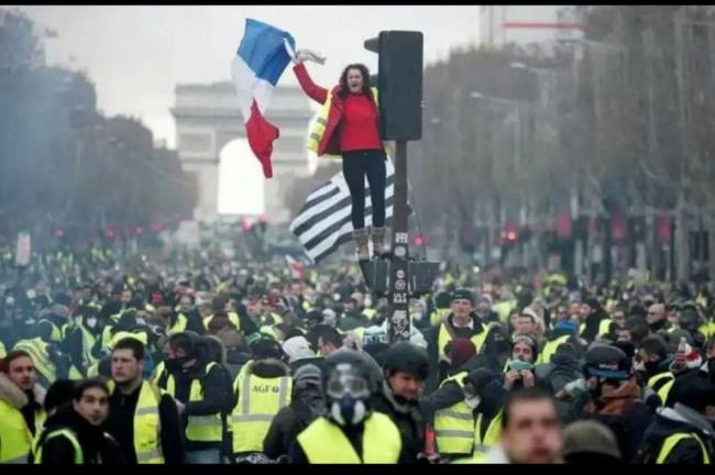 The Gilets Jaune, or Yellow Vests, fill the Champs Elysee./Photo by KRIS AUS67/Flickr