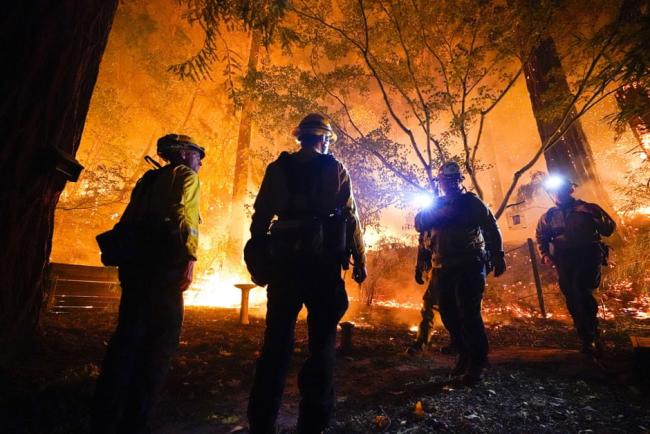 Firefighters make a stand in the backyard of a home in front of the advancing CZU August Lightning Complex fire on Friday 21 August in Boulder Creek, California. Photograph: Marcio José Sánchez/AP