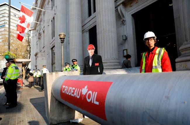 London on April 18, 2018, as they protest against the Trans Mountain oil pipeline from Alberta's oil sands to the Pacific Ocean. In 2016, Canada's Prime Minister Justin Trudeau's government approved tripling the 1,150-kilometer (715-mile) Trans Mountain pipeline's capacity to carry 890,000 barrels of oil for shipping overseas from landlocked Alberta's oil sands to the port of Vancouver. / AFP PHOTO / Tolga AKMEN (Photo credit should read TOLGA AKMEN/AFP/Getty Images)AFP/GETTY IMAGES