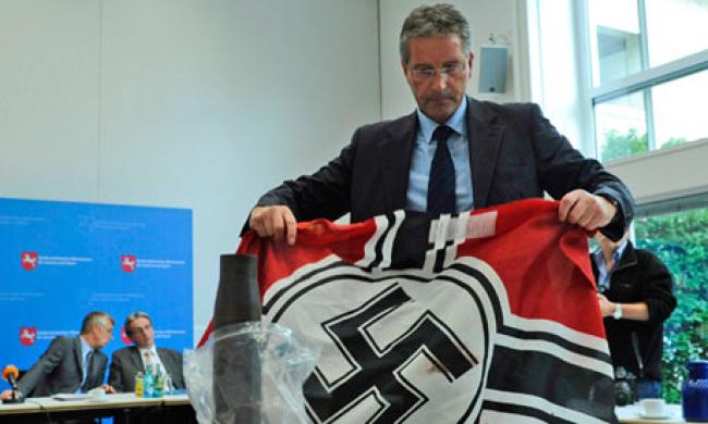 A German police officers shows a Nazi flag confiscated from the far-right group Besseres Hannover. Contrarian climate scientist and conservative media favorite Roy Spencer posted a rant on his blog against those he calls "global warming Nazis." Photograph: Alexander Koerner/AP