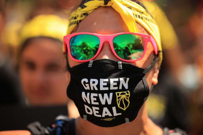 A young climate activist joins hundreds of fellow marchers as they walk to the White House to demand that U.S. President Joe Biden work to make the Green New Deal into law on June 28, 2021 in Washington, D.C. (Photo: Chip Somodevilla/Getty Images)
