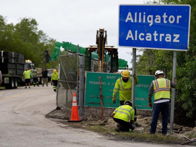 Workers install a sign reading ‘Alligator Alcatraz’ at the entrance to a new migrant detention facility in Florida on July 3, 2025. Photo by Rebecca Blackwell, the Associated Press.