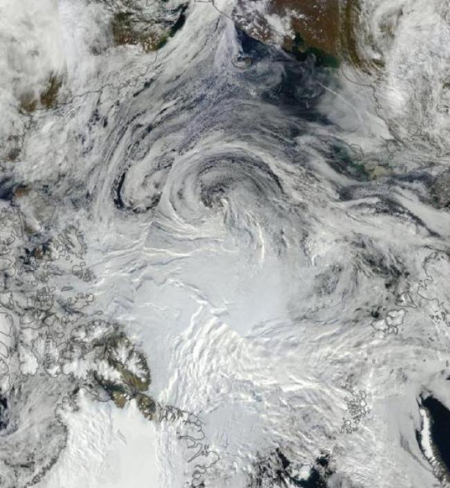 A dark and mostly ice-free Arctic Ocean beneath a   tempestuous swirl of clouds on September 1, 2012,   a time when sea ice coverage had declined to an   area roughly equal to the land mass of Greenland.   Image source: Lance-Modis/NASA AQUA.