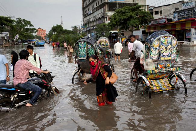 An office worker returning home in Chittagong as the city faces unprecedented flooding due to rising sea level, the release of water from the Kaptai Lake, and the suspension of the Karnaphuli River dredging. Credit: K M Asad/LightRocket via Getty Images