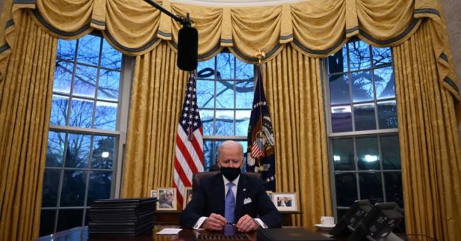 US President Joe Biden holds a pen as he prepares to sign a series of orders in the Oval Office of the White House in Washington, DC, after being sworn in at the US Capitol on January 20, 2021. (Photo: JIM WATSON/AFP via Getty Images)