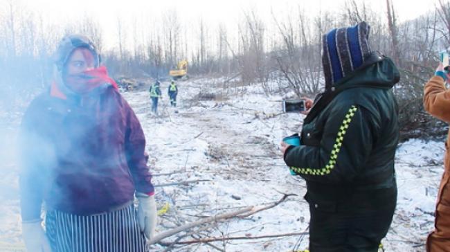 Site C opponents Christy Jordan-Fenton and Yvonne Tupper wait for Saulteau Security employees to pass during a patrol near their encampment at Rocky Mountain Fort earlier this month.   Photo By Jonny Wakefield 