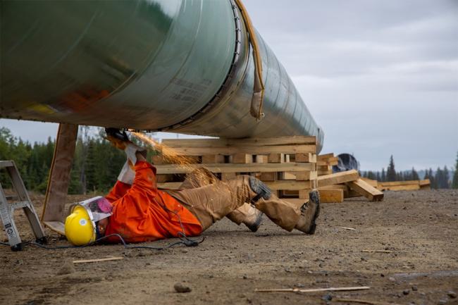 A worker welds a section of the Coastal GasLink pipeline near Vanderhoof. An application for judicial review says the B.C. government has not properly laid out how its plan to reduce GHG emissions will account for new natural gas production facilities, like LNG Canada.Coastal GasLink