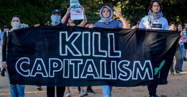Participants hold a "Kill Capitalism" banner while marching through Central Park in New York City. (Photo: Erik McGregor/LightRocket via Getty Images)
