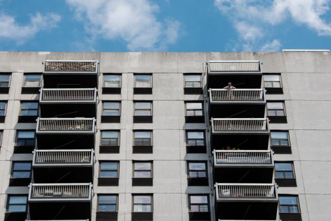 A man stands on the balcony of a high-rise building in New York City. (Bryan Thomas / Getty Images)