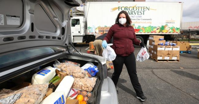 A volunteer with Forgotten Harvest loads food into a vehicle at a mobile pantry April 14, 2020 in Detroit, Michigan. The organization distributes food throughout the metro area, which has seen an uptick in demand due to the COVID-19 pandemic. (Photo: Gregory Shamus/Getty Images)
