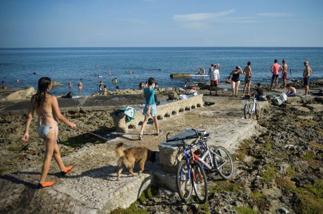 People enjoy the day on the coast along Havana's Malecon on July 3, 2020. (Yamil Lage / AFP via Getty Images)