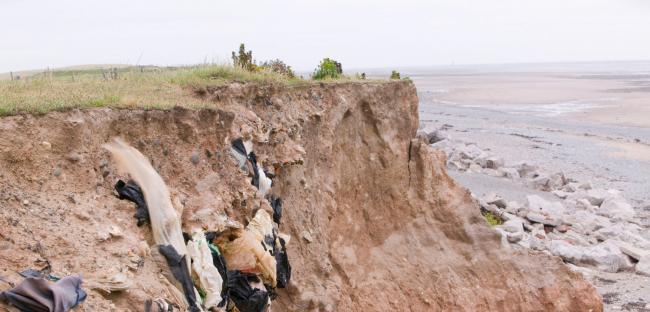 Thousands of landfills built over the past century, like this one on Walney Island, England, are susceptible to flooding, sea level rise, and coastal erosion. Photo by Global Warming Images/Alamy Stock Photo