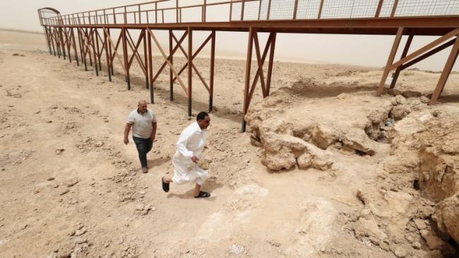 Iraqis visit an area near the pond remaining of Sawa Lake, due to climate change-induced drought, in Samawa city, Iraq, on May 1. The WMO says there's a 50 per cent chance the world will hit 1.5 C of warming temporarily by 2026. (Alaa Al-Marjani/Reuters)