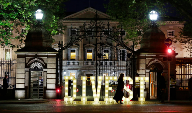 A message to divest from fossil fuels in front of Ireland's parliament buildings. Photo: Sasko Lazarov/Photocall Ireland/Trócaire/350.org