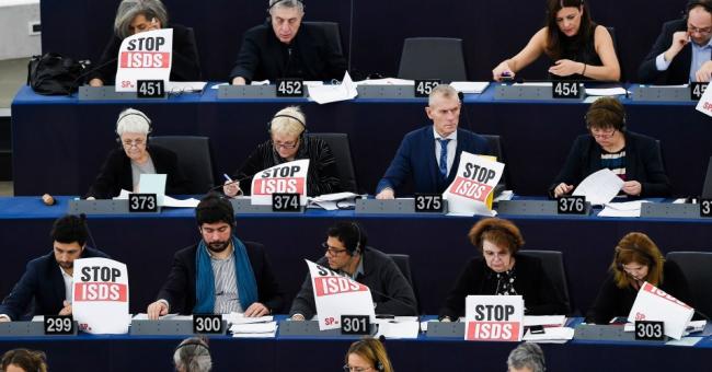 Members of the European Parliament hold posters reading "Stop ISDS" (investor-state dispute settlement) as they take part in a voting session on February 13, 2019 in Strasbourg, France. (Photo: Frederick Florin/AFP via Getty Images)