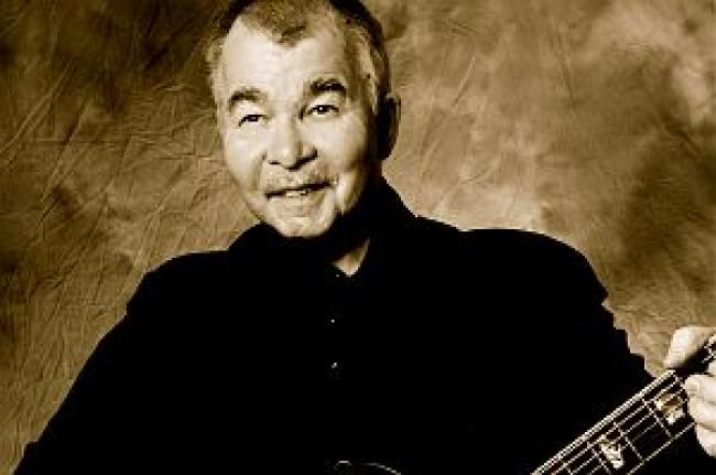 John Prine performing with guitar in later years.