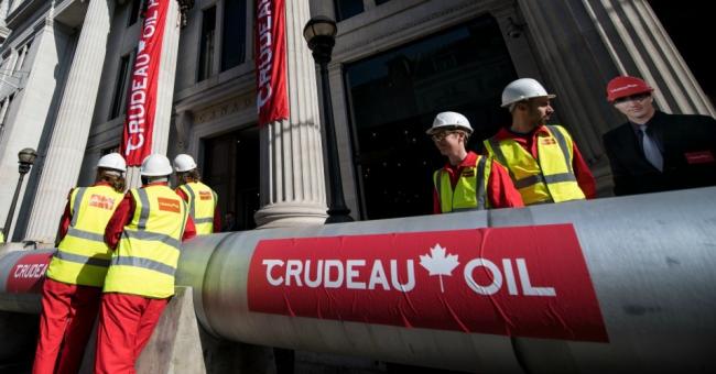 Greenpeace activists unfurl banners after building a wood and card 'oil pipeline' outside the Canadian High Commission, Canada House, to protest against the Trudeau government's plans to build an oil pipeline in British Columbia on April 18, 2018 in London. (Photo: Chris J Ratcliffe/Getty Images)
