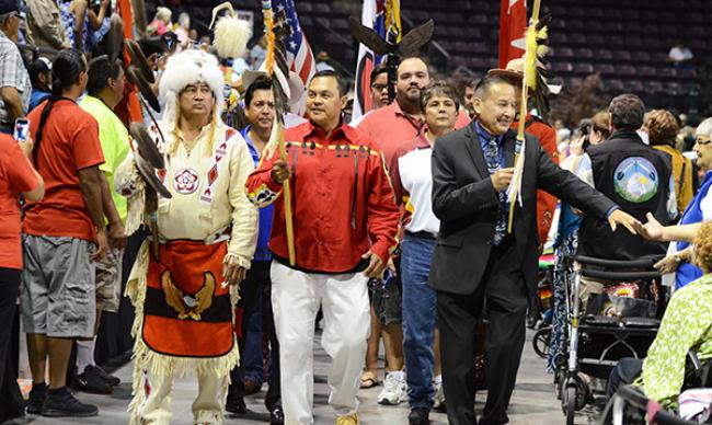 Grand Chief Stewart Phillip of Penticton reaches out to an audience member during the grand entry of the delegates to the 2014 BC Elders Gathering at the South Okanagan Events Centre. — Image Credit: Penticton Western News File Photo
