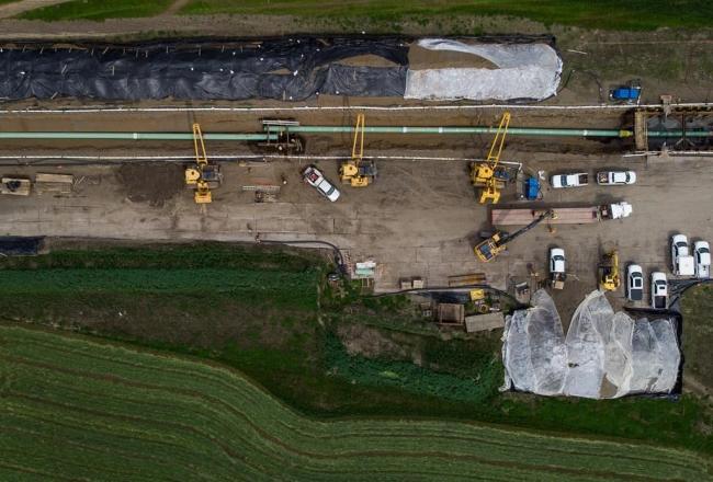 In this photograph taken with a drone, workers lay pipe during construction of the Trans Mountain pipeline expansion on farmland, in Abbotsford, B.C. Photo by: The Canadian Press/Darryl Dyck