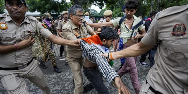 Security personnel detain a protestor during a march towards Parliament on July 20. Photo: PTI.
