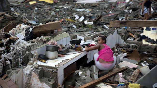 A woman searches amid the rubble of her home destroyed by Hurricane Matthew in Baracoa, Cuba, Wednesday, Oct. 5, 2016.(AP Photo/Ramon Espinosa)