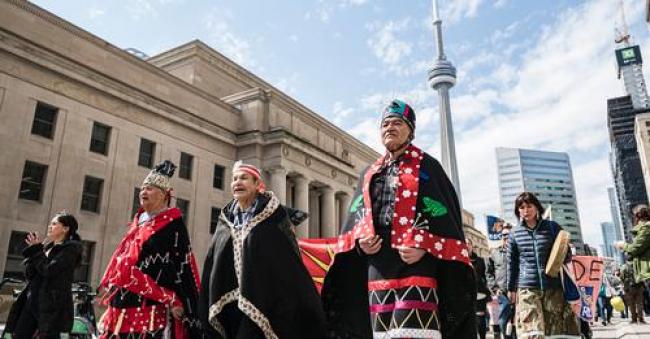 Wet’suwet’en nation hereditary Chief Namoks (right) walks with Chief Gisdaya (centre) and Chief Madeek while in Toronto for the Royal Bank of Canada annual general meeting, on Thursday, April 7, 2022. (Christopher Katsarov / Canada's National Observer)