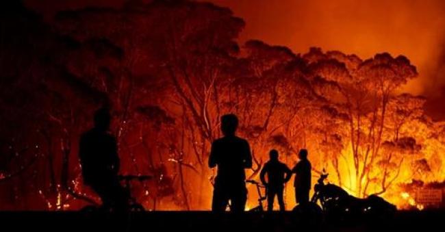 Residents look on as flames burn through bush on January 4, 2020 in Lake Tabourie, Australia. (Photo: Brett Hemmings/Getty Images)