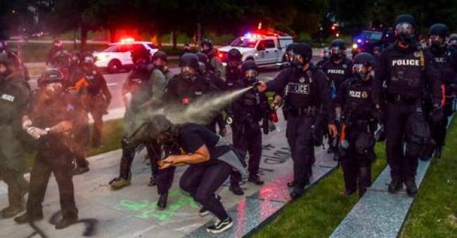 Police officers pepper spray a woman next to the Colorado State Capitol as protests against the killing of George Floyd continue on May 30, 2020 in Denver, Colorado. (Photo: Michael Ciaglo/Getty Images)