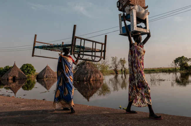 Residents carry their belongings away from the floodwaters that have engulfed a swath of South Sudan for almost a year, uprooting nearly a million people. Climate change is causing catastrophes throughout the developing world. Photo courtesy of MSF