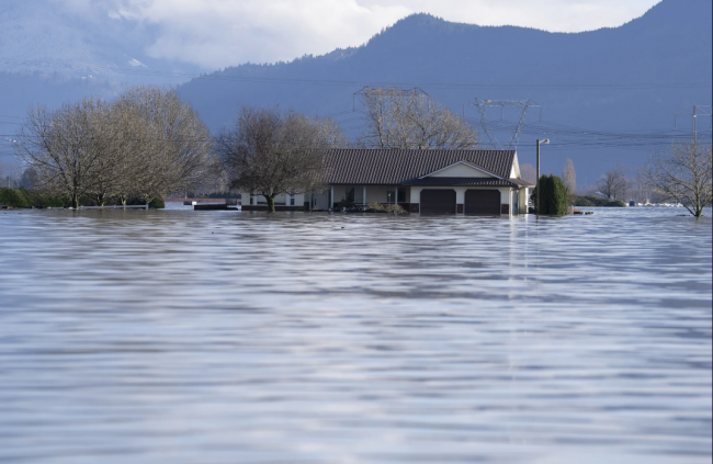 A home is surrounded by floodwaters caused by heavy rains and mudslides throughout Sumas Prairie near Chilliwack, B.C., Friday, Nov. 19, 2021. THE CANADIAN PRESS/Jonathan Hayward
