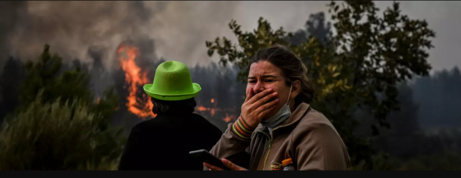 A local reacts to watching a wildfire advancing in Orjais, Covilha council in central Portugal, on August 16, 2022. (Photo: Patricia De Melo Moreira/ AFP via Getty Images)