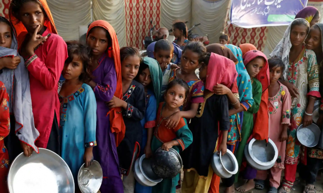 ‘Pakistan is suffering not just from flooding, but from recurring climate extremes.’ People queue for food in Sehwan. Photograph: Akhtar Soomro/Reuters