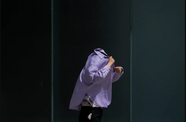 A woman tried to shield herself from the sun in Beijing, where temperatures reached 104 degrees Fahrenheit on Thursday.Credit...Andy Wong/Associated Press
