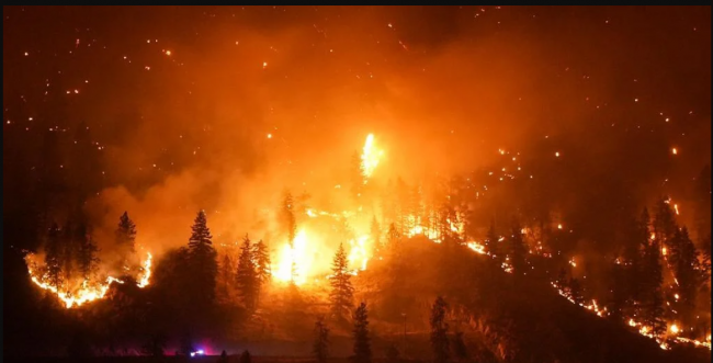The McDougall Creek wildfire burns on the mountainside above a lakefront home, in West Kelowna, B.C., on Friday, Aug. 18, 2023. File photo by The Canadian Press/Darryl Dyck