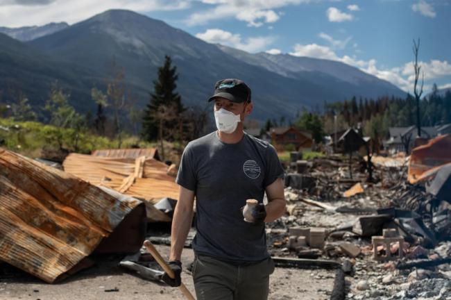 A homeowner digs in the ashes of their home as some return to Jasper, Alberta on Monday August 19, 2024.  Photo by:  The Canadian Press/Amber Bracken