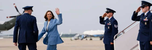 The Rising Democratic Threat of "Hopeful Militarism" U.S. Vice President and Democratic presidential candidate Kamala Harris waves after stepping off Air Force Two upon arrival at Joint Base Andrews in Maryland on August 16, 2024. (Photo by Erin Schaff/POOL/AFP via Getty Images)