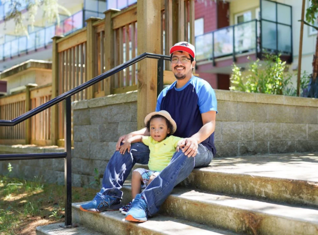 A father and his son sit on the steps of their non-profit Indigenous housing in Metro Vancouver. It’s a secure oasis in a city of high rents, discriminatory barriers and uncertainty for many Indigenous families. All photos courtesy of the Aboriginal Housing Management Association.