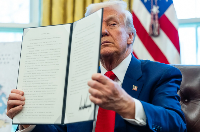 President Trump held up an executive order at a signing ceremony in the Oval Office this month.Credit...Eric Lee/The New York Times