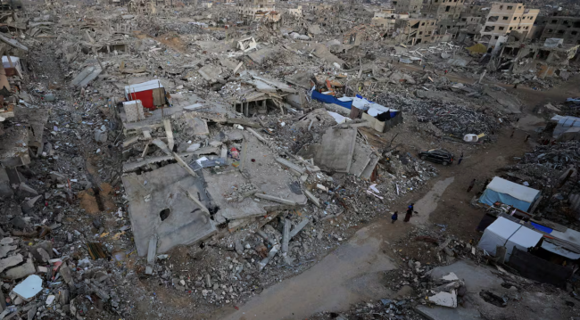 Palestinians stand near rubble from destroyed buildings, amid a ceasefire between Israel and Hamas, in Gaza City, on Monday. (Dawoud Abu Alkas/Reuters)