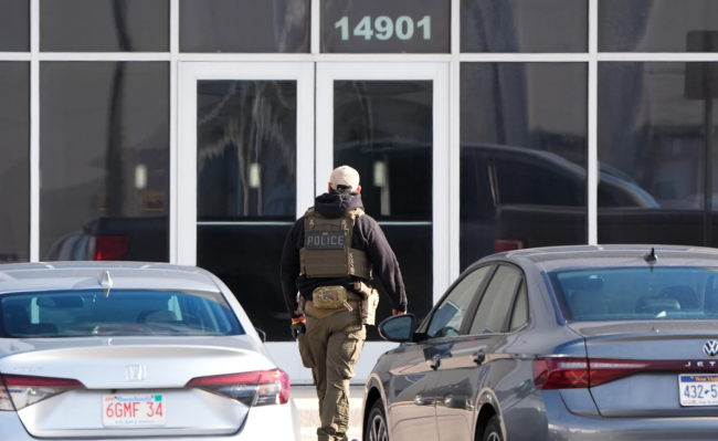 A US Immigration and Customs Enforcement agent stands outside a warehouse being toured for repurposing into a detention facility in Kansas City, Missouri, on Thursday, Jan. 15, 2026. ICE is seeking a Hanover County building for immigrant processing.