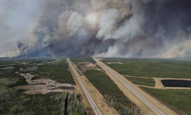 Smoke from fires billows south of Fort McMurray as seen from a helicopter over Highway 63. Photograph: Mcpl Vanputten/AFP/Getty Images