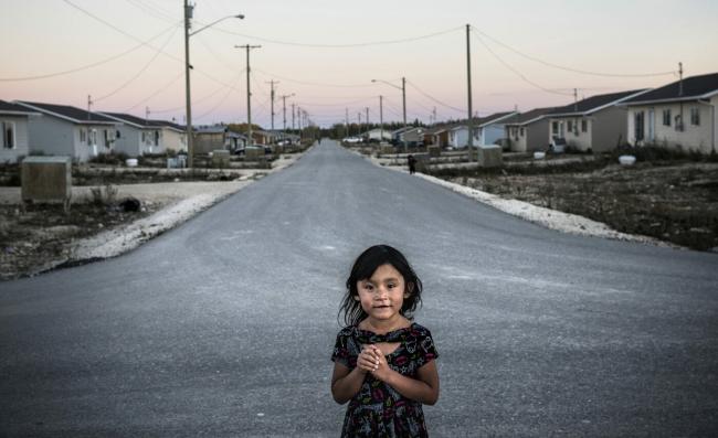 A portrait of a young girl on the streets of Easterville, Manitoba. Easterville is the reserve community of the Chemawawin Cree Nation, founded in 1962 after they were forcibly relocated during the construction of the Grand Rapids dam which flooded 202,343 hectares of land. Photo: Aaron Vincent Elkaim / The Narwhal