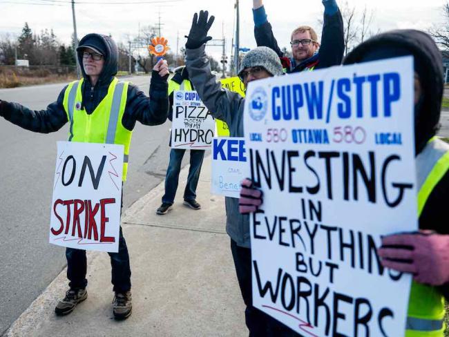 Striking Canada Post employees, like those picketing in Ottawa, are caught in a larger battle over work in Canada. Photo by Spencer Colby, the Canadian Press.